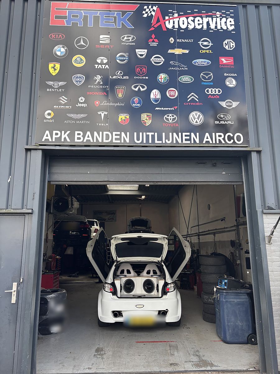 De ingang van Ertek Autoservice aan de Marconiweg, met het bord APK, banden, uitlijnen, airco